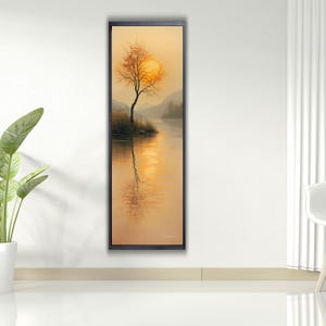 Puede incluir: Pintura de paisaje enmarcada que representa un árbol silueteado contra un sol poniente, reflejado en el agua. La obra utiliza tonos cálidos de naranja, amarillo y marrón, creando una escena serena. La pintura está enmarcada en negro.