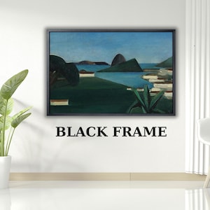 May include: A rectangular landscape painting in a black frame featuring a blue sky, a calm body of water, and green hills. The artwork displays a coastal scene with dark green foliage in the foreground and light-colored structures near the water.