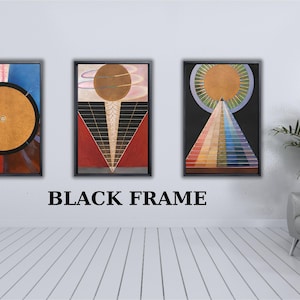 May include: Three framed wall art prints featuring geometric compositions. The left print shows a large gold circle on a blue and yellow background. The centre print displays a gold sphere above a red triangle. The right print features a gold sun above a colourful spectrum pyramid. Each piece is enclosed in a black frame.