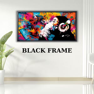 May include: A framed art print featuring a colorful graffiti-style design. The artwork depicts a monkey wearing headphones, set against a vibrant backdrop of blues, pinks, and yellows. The frame is black, and the text "BLACK FRAME" is below the artwork.