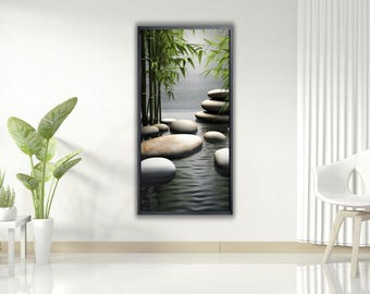 May include: A framed vertical print depicts a serene zen garden scene. Smooth, rounded stones rest in calm water, with bamboo stalks and foliage adding a touch of green. The artwork evokes tranquility and natural beauty.