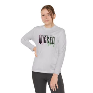 May include: A light gray long-sleeve shirt with the text "The weather outside is WICKED" in black, pink, and green. The shirt is made of a soft, comfortable material.