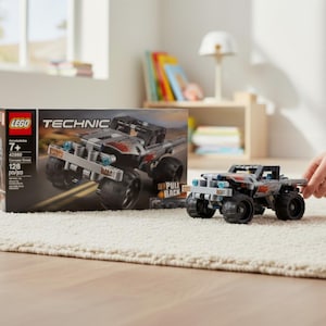Può includere: Un set di giocattoli LEGO Technic monster truck, con un camion grigio e nero con decalcomanie a fiamma rossa. La scatola mostra lo stesso design del camion. Il set include 128 pezzi ed è per bambini dai 7 anni in su.