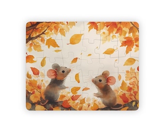 May include: A rectangular puzzle featuring a watercolor illustration of two mice in an autumn scene. The mice, with gray fur and pink ears, are surrounded by orange and yellow leaves. The puzzle pieces are white.