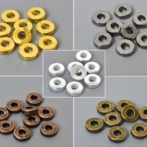 May include: Assortment of metal spacer beads in gold, silver, and antique brass finishes. The beads are round with a hole in the center.