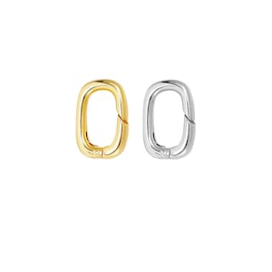 May include: Two oval-shaped clasps, one gold-toned and one silver-toned, are displayed against a white background. The clasps have a smooth, polished finish and a simple, modern design. They are likely used for jewelry or accessories.