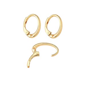 May include: Three gold-colored hoop earrings, two closed and one open, are displayed against a white background. The earrings have a simple, elegant design with a hinged closure. The metal has a shiny finish.