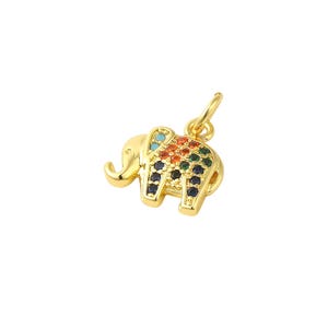 May include: A gold-colored elephant charm with a loop for hanging. The elephant is adorned with colorful gemstones in shades of blue, orange, green, and black. The charm is likely for a necklace or bracelet.