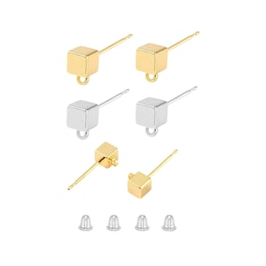 May include: A collection of cube-shaped stud earring components in gold and silver tones. The earrings have a post and loop design. Included are several earring backs. The earrings are displayed on a white background.