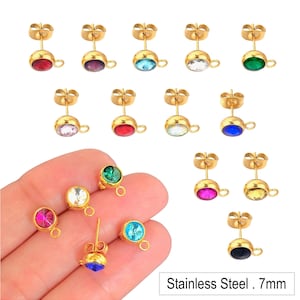 May include: Assortment of 12 pairs of gold-tone stainless steel stud earrings with 7mm round crystal accents in various colors, including red, pink, blue, green, yellow, and black.