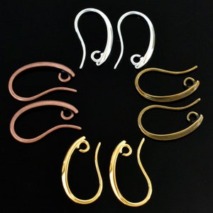 May include: Assortment of earring hooks in silver, copper, gold, and bronze finishes. The hooks are all the same size and shape, with a slight curve.