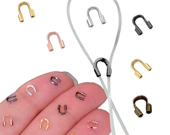 May include: Assortment of metal crimp end bead tips in various colors, including gold, silver, black, rose gold, and bronze. The tips are shown on a white cord.