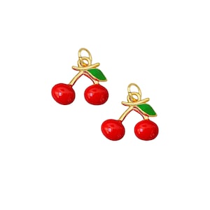 May include: Two gold-tone cherry charms with red enamel cherries and green enamel leaves.