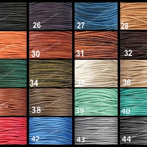 May include: A selection of leather cord spools in a range of colours, such as black, blue, brown, green, and red. Each spool is numbered from 25 to 44. The tightly wound cords display their texture and colour variations.