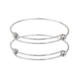May include: Two silver bangle bracelets with textured surfaces and knotted ends.