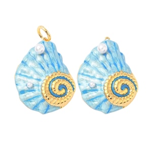 May include: Two seashell-shaped pendants with a light blue enamel finish and gold-colored spiral accents. Each pendant features a small white pearl and a gold-colored loop for hanging. The pendants are designed to resemble nautilus shells.