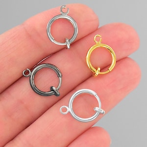 May include: Four jump rings in different finishes: silver, gold, black, and gunmetal. Each ring has a small loop at the top for attaching to a chain or other jewelry.
