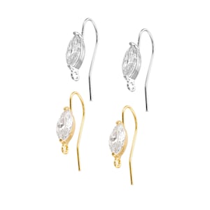 May include: Four earring findings with clear marquise-shaped crystals. Two findings are gold-toned and two are silver-toned.