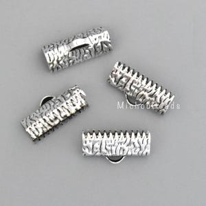 May include: Four silver-colored crimp end findings with a textured, bark-like pattern. Each finding has a loop for attaching to jewelry. The findings are displayed on a light gray surface. The text "MichouBeads" is visible.