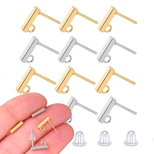 May include: A set of 12 gold and silver earring posts with a rectangular bar and a loop at the top. The posts are shown on a white background with three clear earring backs.