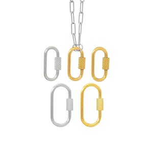 May include: A silver chain necklace with five oval-shaped pendants. Two pendants are silver, and three are gold. Each pendant has a textured screw-lock closure. The pendants are displayed against a white background.