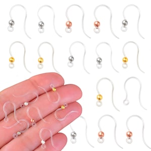 May include: A set of 18 clear plastic earring hooks with a small metal ball at the end. The balls are available in silver, gold, rose gold, and black.