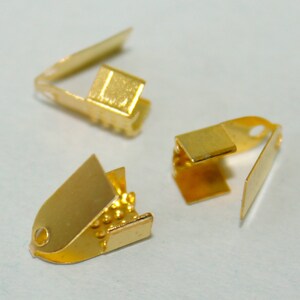 Pu&ograve; includere: Tre chiusure in metallo dorate per la creazione di gioielli. Le chiusure sono di forme e dimensioni diverse. Una chiusura &egrave; piccola, di forma rettangolare con un coperchio incernierato. Un'altra chiusura &egrave; piccola, di forma ovale con un coperchio incernierato. La terza chiusura &egrave; pi&ugrave; grande, di forma rettangolare con un coperchio incernierato.