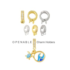 May include: An assortment of openable charm holders in gold and silver tones, some encrusted with small, clear stones. A charm with a blue and gold turtle and wave design is also shown. The text "OPENABLE Charm Holders" is displayed.