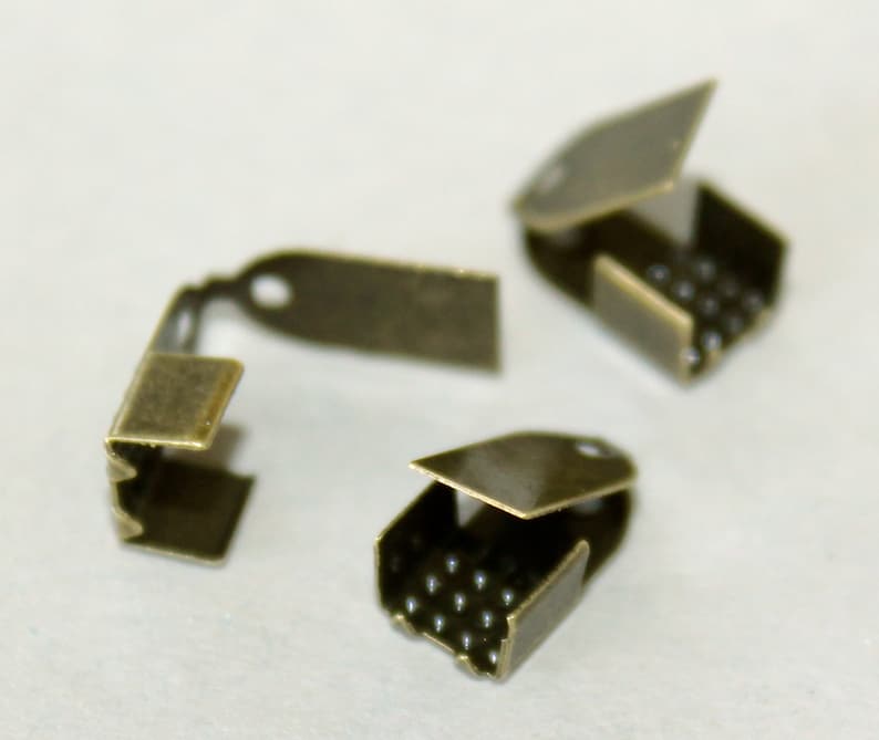 Pu&ograve; includere: Tre chiusure in metallo color oro antico per la creazione di gioielli. Ogni chiusura ha un coperchio incernierato con una fila di piccole sfere di metallo.