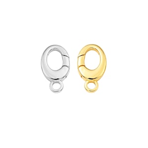 May include: Two oval-shaped jewelry clasps, one silver-colored and one gold-colored, are displayed against a white background. Each clasp has a small loop at the bottom for attaching to jewelry pieces. The clasps are designed to securely fasten necklaces or bracelets.