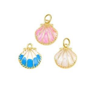 May include: Three seashell charms with gold-colored metal edging and loops. One charm is pink, one is white and blue, and the other is white. The charms are likely for jewelry making or crafting.