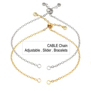 May include: Two adjustable cable chain bracelets, one gold-toned and one silver-toned, with small clear gemstones. The bracelets have a slider clasp for easy adjustment. Text on the image reads: CABLE Chain, Adjustable, Slider, Bracelets.