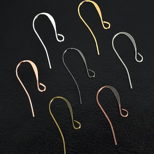 May include: An assortment of earring hooks in various metallic finishes, including silver, gold, and copper. The hooks are displayed against a dark background, showcasing their curved design and looped ends. These jewelry findings are ideal for creating custom earrings.