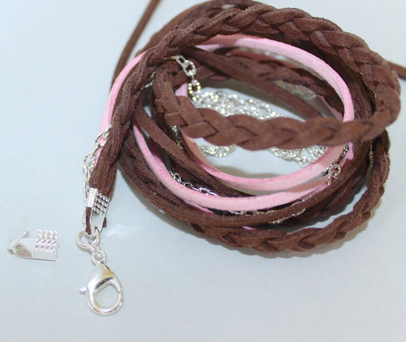 Pu&ograve; includere: Un cordoncino in pelle intrecciata marrone e rosa con una chiusura argentata. Il cordoncino &egrave; composto da pi&ugrave; fili di pelle intrecciati insieme. Il cordoncino &egrave; lungo circa 25 cm e ha una chiusura argentata a un'estremit&agrave;.