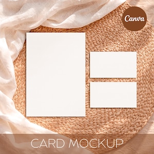 May include: A card mockup featuring a large white rectangular card and two smaller rectangular cards, arranged on a woven, circular placemat. The text "CARD MOCKUP" is at the bottom. A fabric is draped over the top left corner. The Canva logo is in the top right corner.