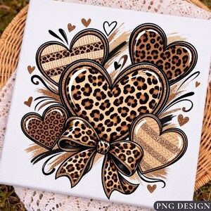 May include: A white square canvas featuring a graphic illustration of multiple hearts with leopard print and tan knit textures. A large leopard print bow is positioned at the bottom center, surrounded by small scattered heart shapes and brush strokes.