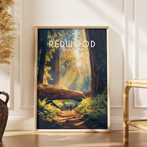 May include: A framed print showcasing a scenic view of Redwood National Park. The artwork depicts a path through a forest with tall trees, a fallen log, and two figures walking. The text "REDWOOD NATIONAL PARK" is displayed at the top.