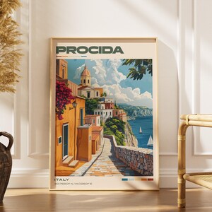 May include: A vertical wall art print titled PROCIDA ITALY featuring a coastal scene with orange buildings, a stone path, a domed church, and sailboats on the blue sea. The print includes the text PROCIDA at the top and ITALY 40.7650 N 14.0260 E at the bottom.