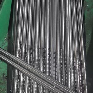 May include: A close-up shot of numerous, parallel, cylindrical metal rods. The rods are silver in color and have a textured pattern near the ends. The arrangement suggests a manufacturing or industrial setting. The rods are neatly aligned, creating a sense of order.