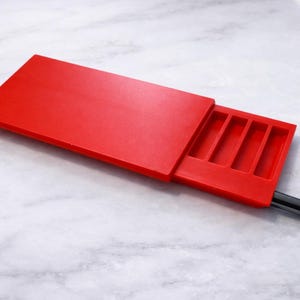 May include: A white ceramic mug with a black handle and the text "But First, Coffee" in a bold, black font. The mug is set against a neutral background, highlighting its simple design.