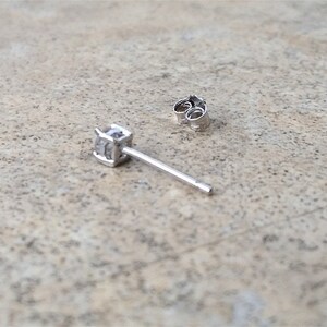 May include: A single silver earring with a small clear cubic zirconia stone.