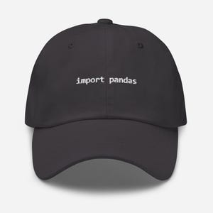 Puede incluir: Gorra de béisbol gris oscuro con el texto blanco "import pandas" en la parte delantera. La gorra tiene una visera curva y un botón en la parte superior. Un accesorio para programadores y científicos de datos.