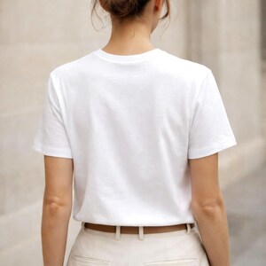 Back view of white t-shirt on woman, relaxed fit, minimalist clothing, neutral capsule wardrobe essential