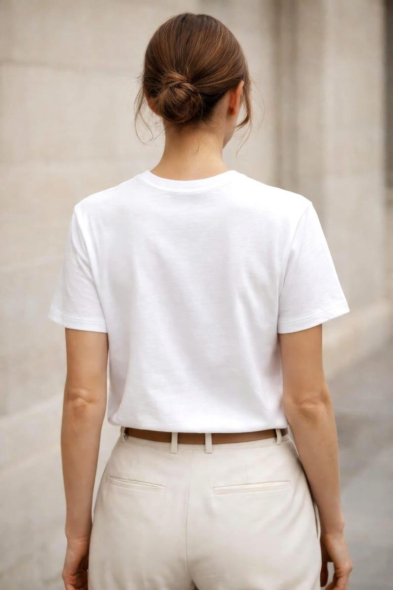Back view of white t-shirt on woman, relaxed fit, minimalist clothing, neutral capsule wardrobe essential