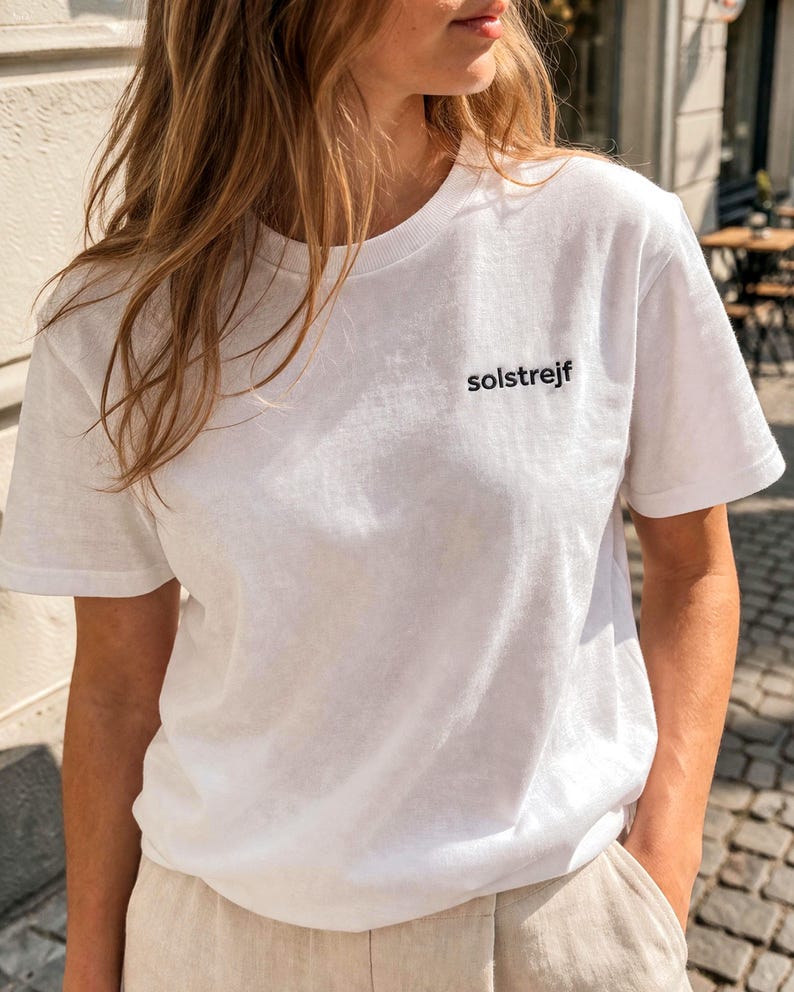 Minimalist white embroidered t-shirt with “solstrejf” text, Scandinavian style outfit, calm neutral aesthetic clothing for women