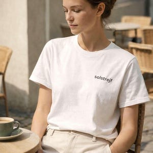 Minimalist white t-shirt styled at café, calm lifestyle outfit, Scandinavian aesthetic clothing for slow living