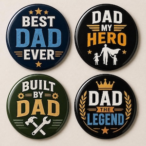 Op de afbeelding: Vier ronde speldjes met berichten voor Vaderdag. De speldjes zijn marineblauw, zwart en groen met tekst in wit, blauw en goud. De tekst bevat "Best Dad Ever", "Dad My Hero", "Built by Dad" en "Dad the Legend".