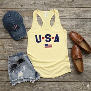 USA Flag Tank Top, perfect for the 4th of July and summer celebrations. This patriotic red, white, and blue tank top features the American flag design, ideal for Independence Day festivities. Whether you’re attending a parade or a BBQ, this tank is the perfect way to showcase your American pride. A thoughtful gift for anyone who loves to celebrate the USA!