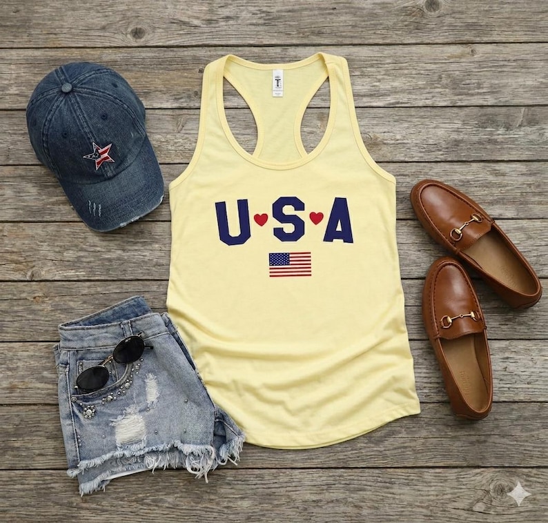 USA Flag Tank Top, perfect for the 4th of July and summer celebrations. This patriotic red, white, and blue tank top features the American flag design, ideal for Independence Day festivities. Whether you’re attending a parade or a BBQ, this tank is the perfect way to showcase your American pride. A thoughtful gift for anyone who loves to celebrate the USA!