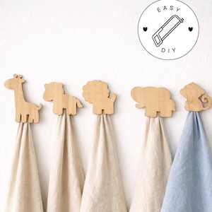 以下が含まれることがあります： キリン、馬、ライオン、ゾウ、サルを模した木製の動物型ウォールフック。各フックには異なる色のタオルが掛けられています。画像には「EASY DIY」の文字とノコギリが描かれた円形のグラフィックが含まれています。